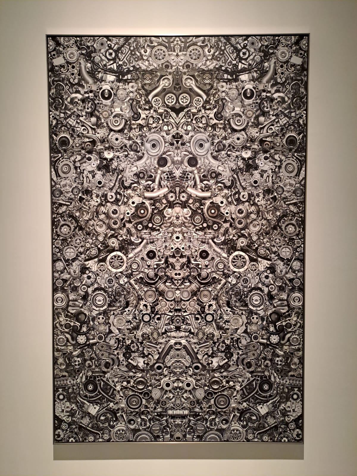 Un quadro che è formato solo da parti meccaniche, come bulloni, parti di motore e chiavi inglesi. sono tutte unite fra loro, creando un opera artistica. dopodiché è stato specchiato.