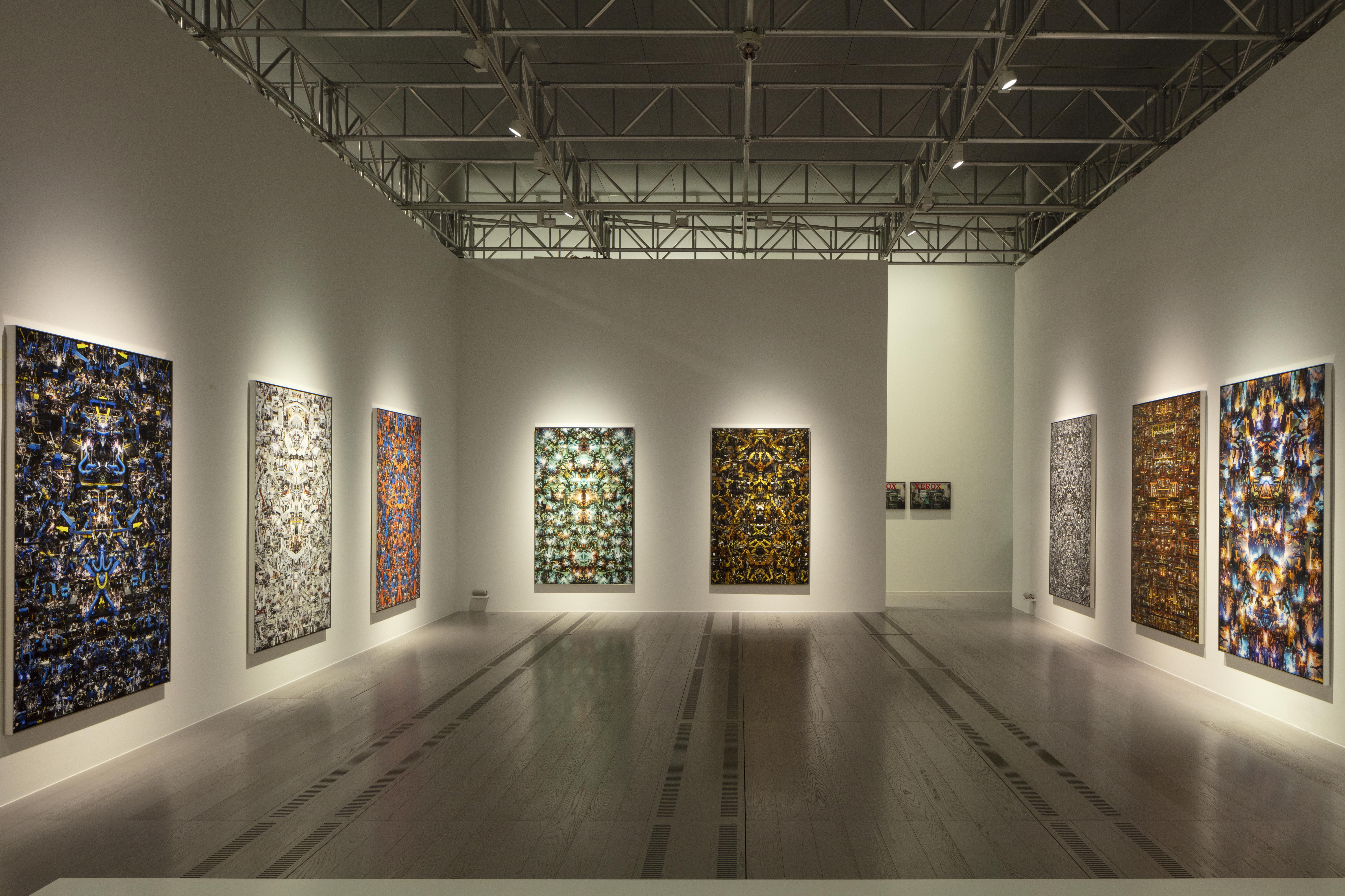 8 quadri su muro bianco, illuminati da dietro. Foto artistiche generate da IA con immagini specchiate.